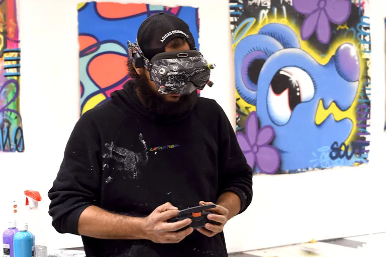 Minneapolis artist trace accomplished, mini drone, pilot, and controls with VR goggles