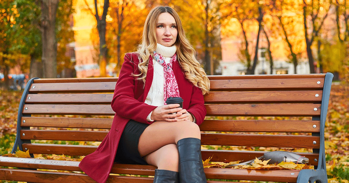 Woman enjoying a colorful fall day in Minneapolis, Minnesota, with autumn leaves, coffee and seasonal clothing.